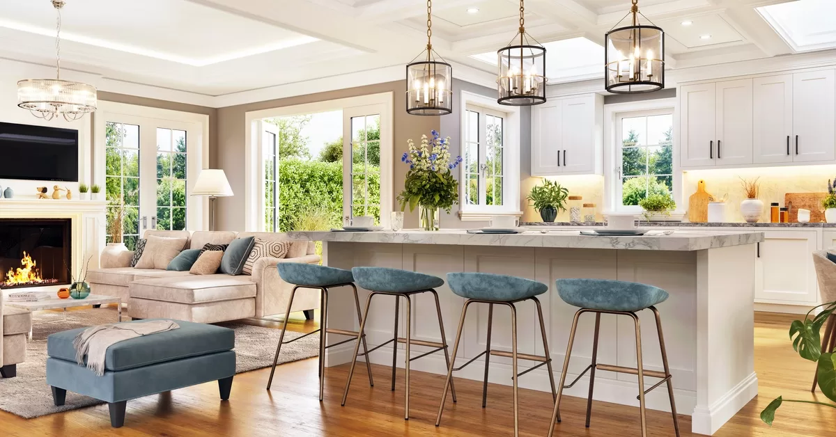 A luxurious open-concept living room and kitchen features high ceilings, a marble island, a fireplace, and large windows.